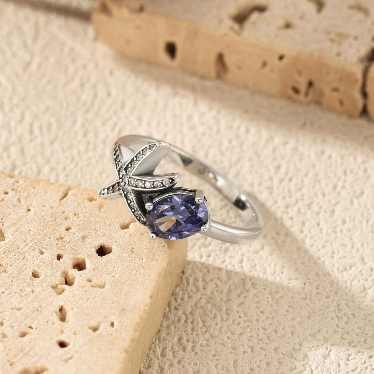 asymmetric oceanic starfish ring in platinum plated s925 sterling silver with micro pave clear cz sea talisman and four prong oval cut tanzanite blue stone