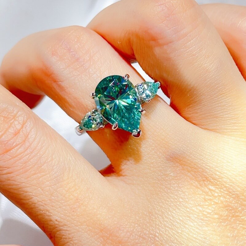 grand 6.0ctw three stone trilogy ring with 5.0ct pear cut intense mint green moissanite center stone and dual 0.5ct teardrop accents on platinum plated s925 silver band