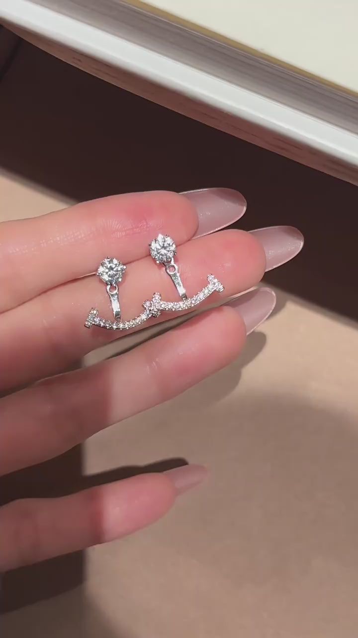 Integrated one-piece smile moissanite double-arc stud earrings in rhodium-plated 925 sterling silver, artfully engineered with a stable snag-free design.
