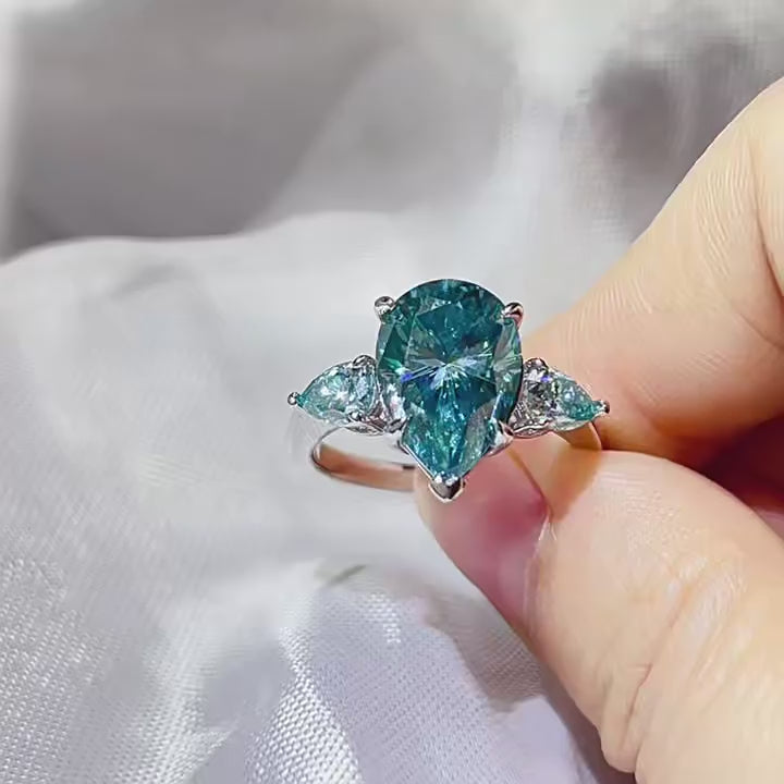 grand 6.0ctw three stone trilogy ring with 5.0ct pear cut intense mint green moissanite center stone and dual 0.5ct teardrop accents on platinum plated s925 silver band
