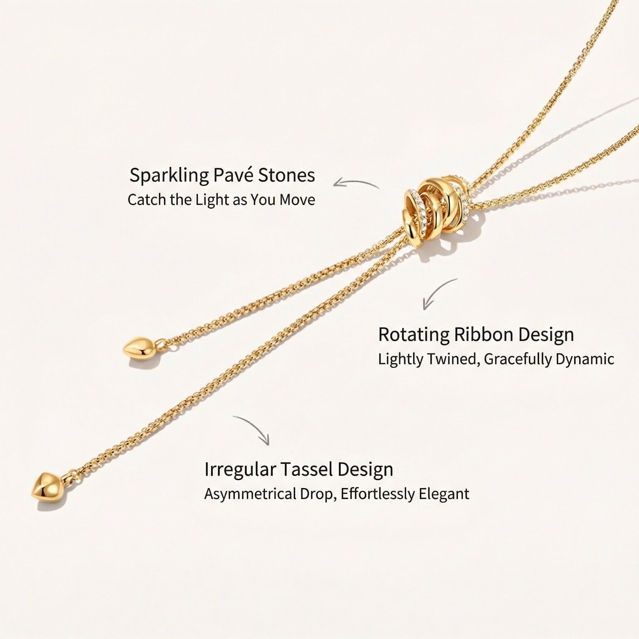 Close-up of a gold lariat necklace featuring sparkling pavé stones, rotating ribbon design, and irregular tassel drops with descriptions.