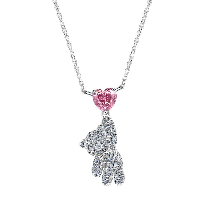 A high-polished 925 sterling silver teddy bear necklace holding a brilliant pink heart moissanite, rhodium plated for a luxury finish.